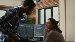 junior developer sitting down desk showing laptop